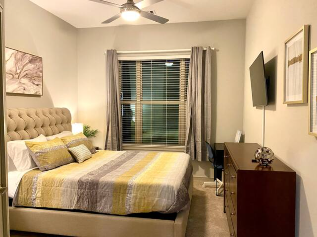 a bedroom with a bed and a ceiling fan