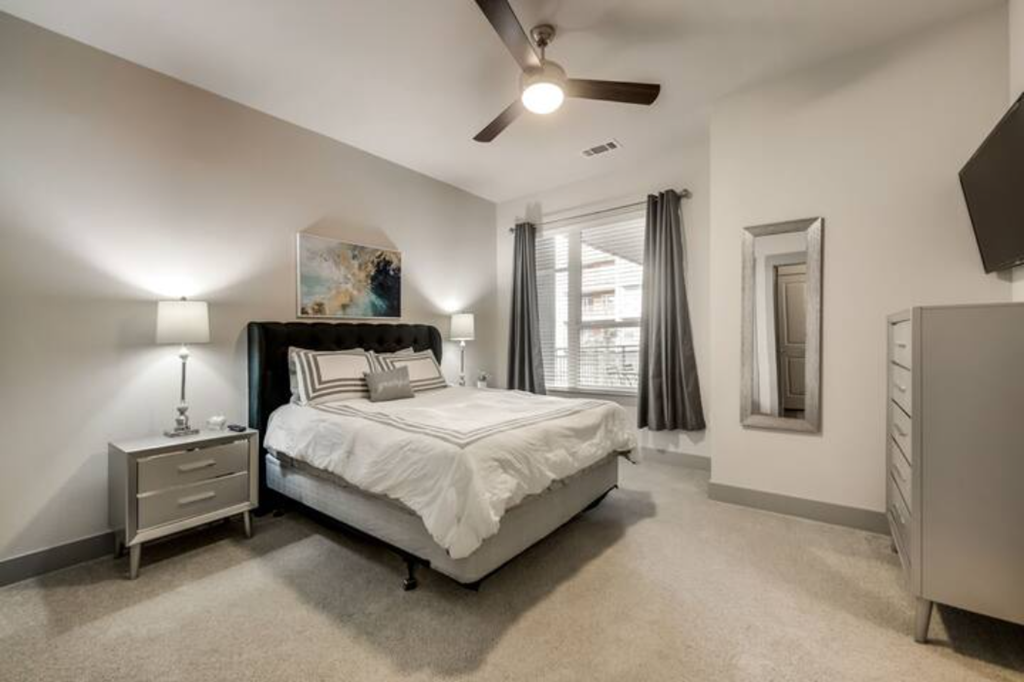 a bedroom with a bed and a ceiling fan