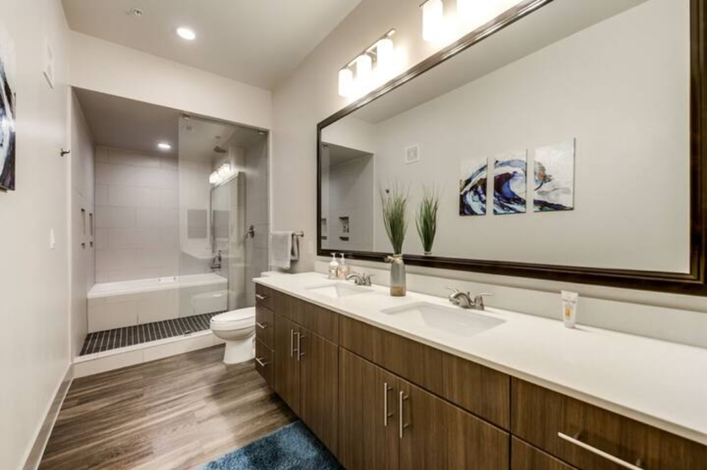 a bathroom with a large mirror and a toilet and a sink
