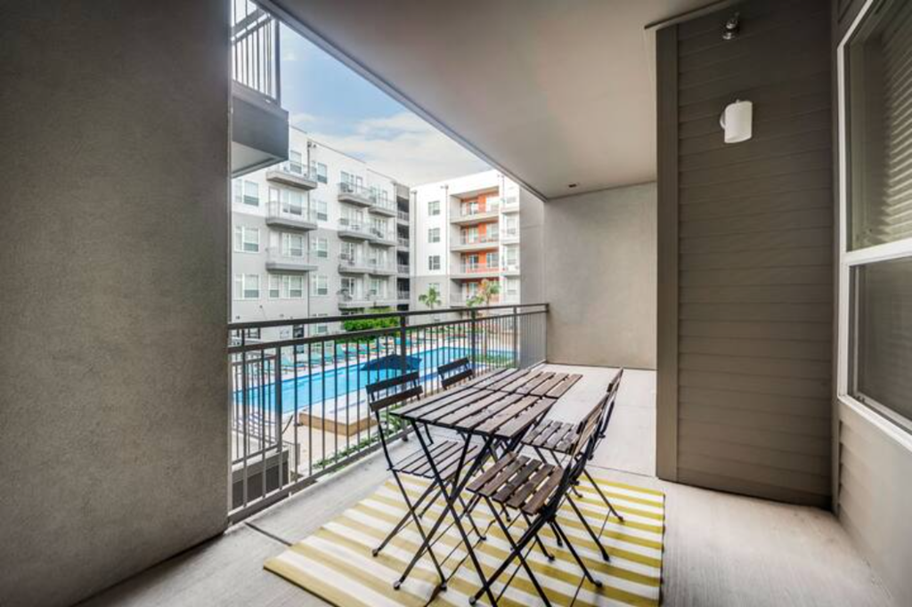 a balcony with a table and chairs and a pool