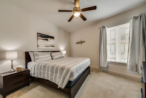 a bedroom with a bed and a ceiling fan