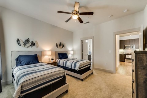 a bedroom with two beds and a ceiling fan