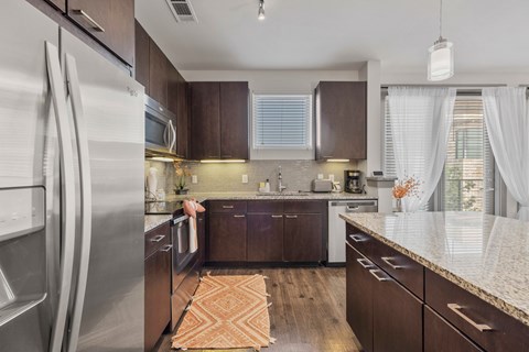 A kitchen with brown cabinets and a white refrigerator.