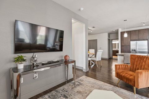 A modern living room with a large television and a brown sofa.