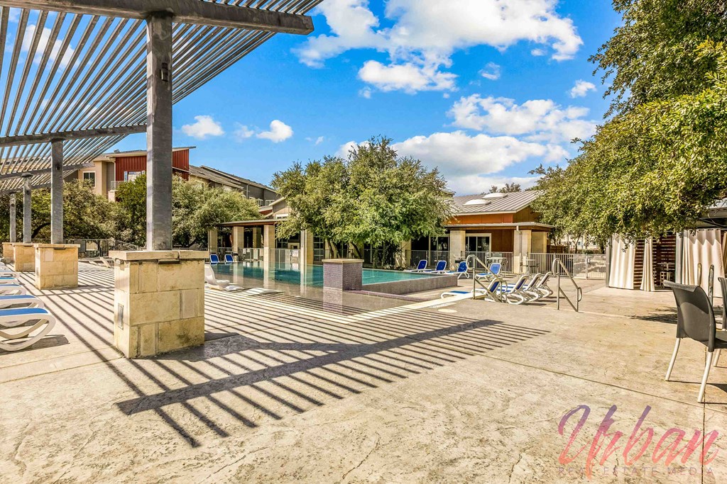 a backyard with a pool and chairs and trees