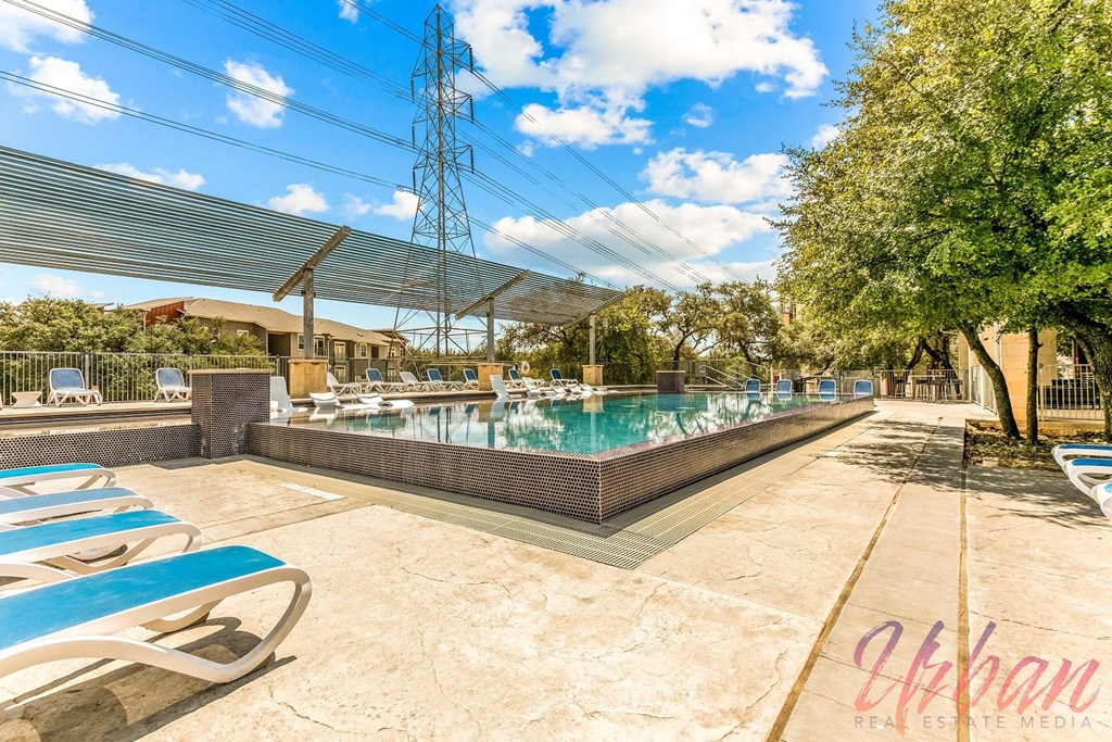a swimming pool with lounge chairs and a resort style pool
