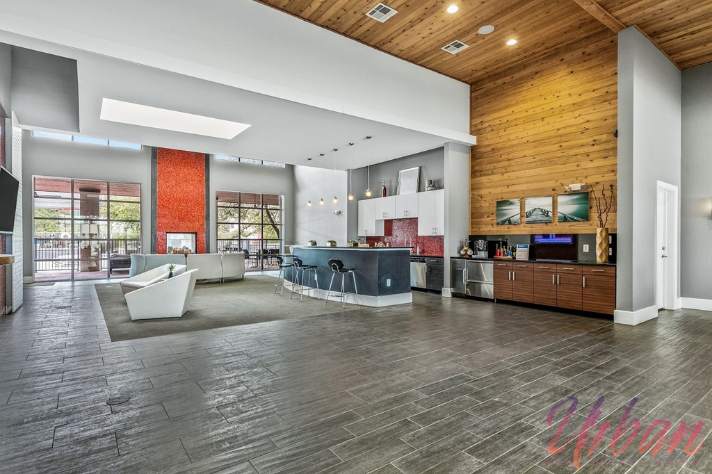a large living room with a kitchen and a large glass door