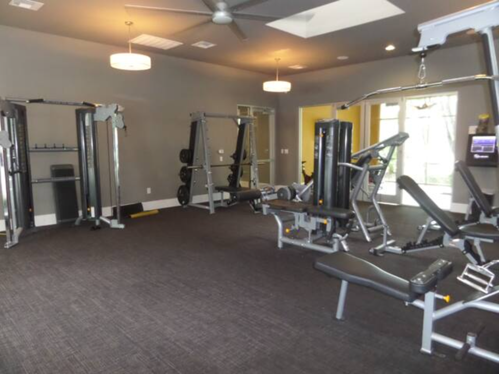 a gym with weights and other equipment in a room with a window