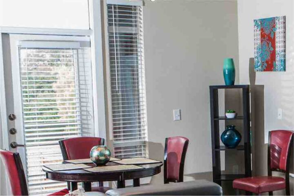 a living room with a table and chairs and a window