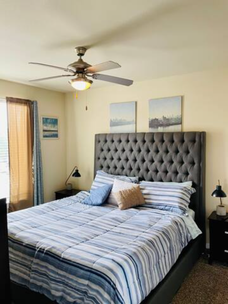 a bedroom with a bed and a ceiling fan