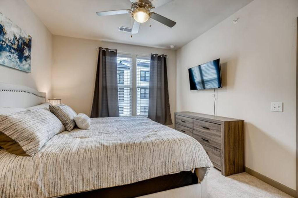 a bedroom with a bed and a ceiling fan