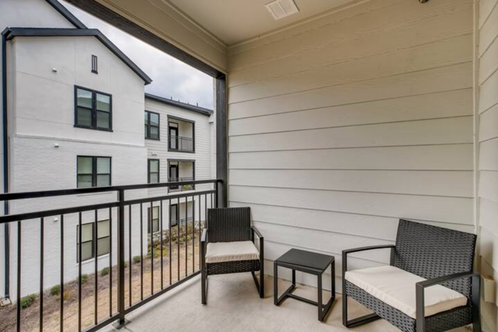 a balcony with two chairs and a table