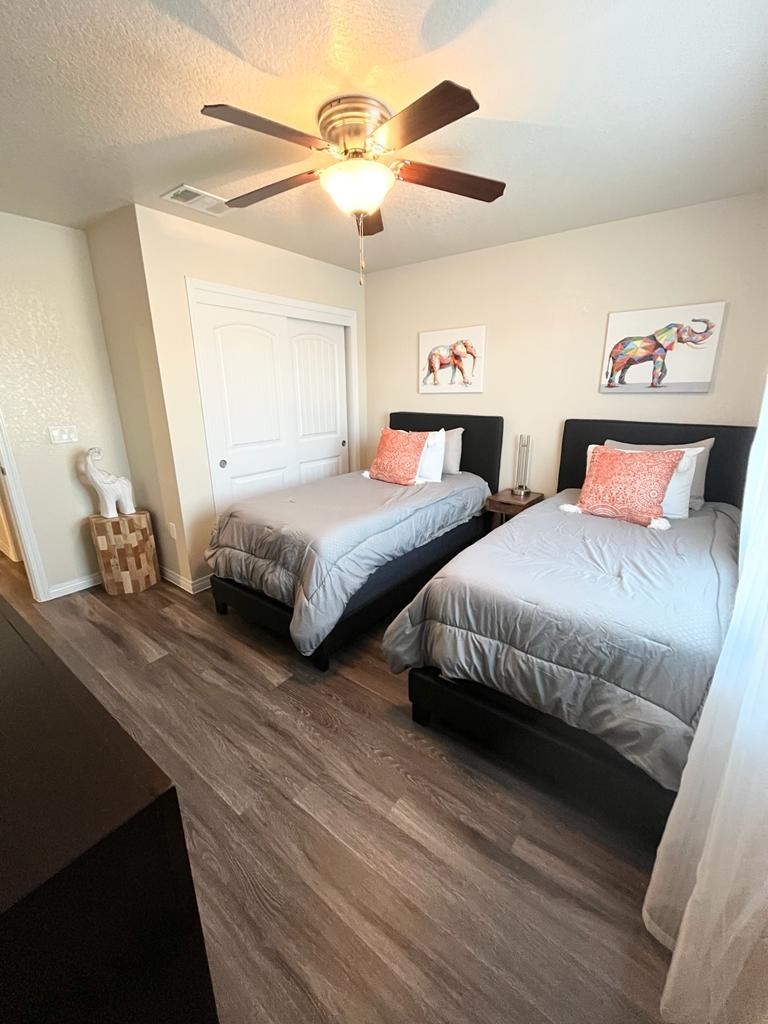 a bedroom with two beds and a ceiling fan