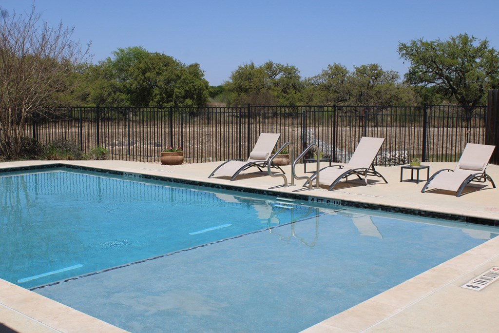 a swimming pool with two lounge chairs next to it