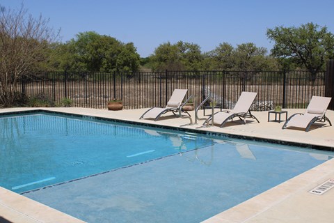 a swimming pool with two lounge chairs next to it
