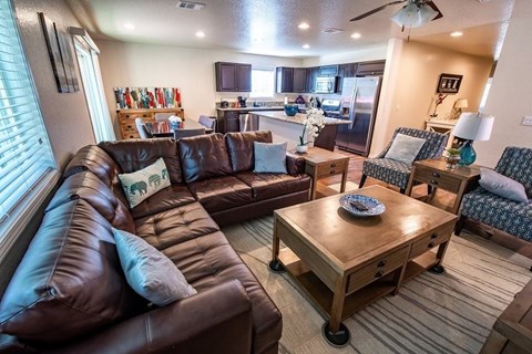 a living room and kitchen with couches and a table