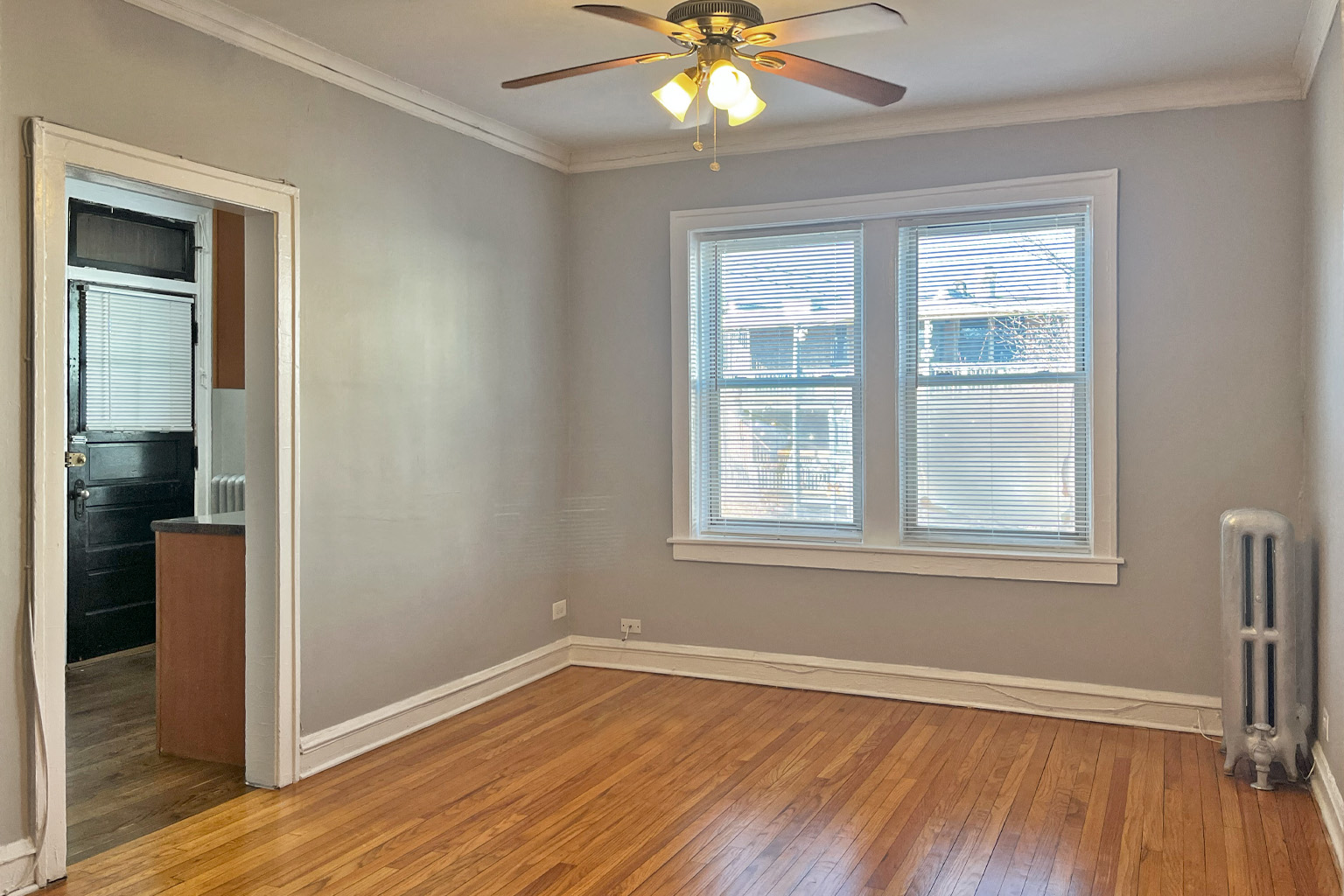 A room with a ceiling fan and a window.