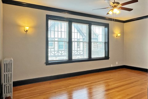 A room with a ceiling fan and a window.