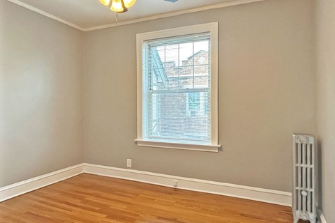 A room with a window and a radiator on the floor.