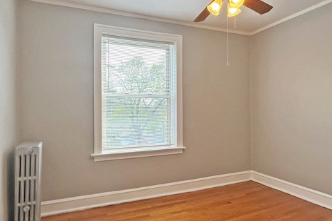 A room with a window and a ceiling fan.