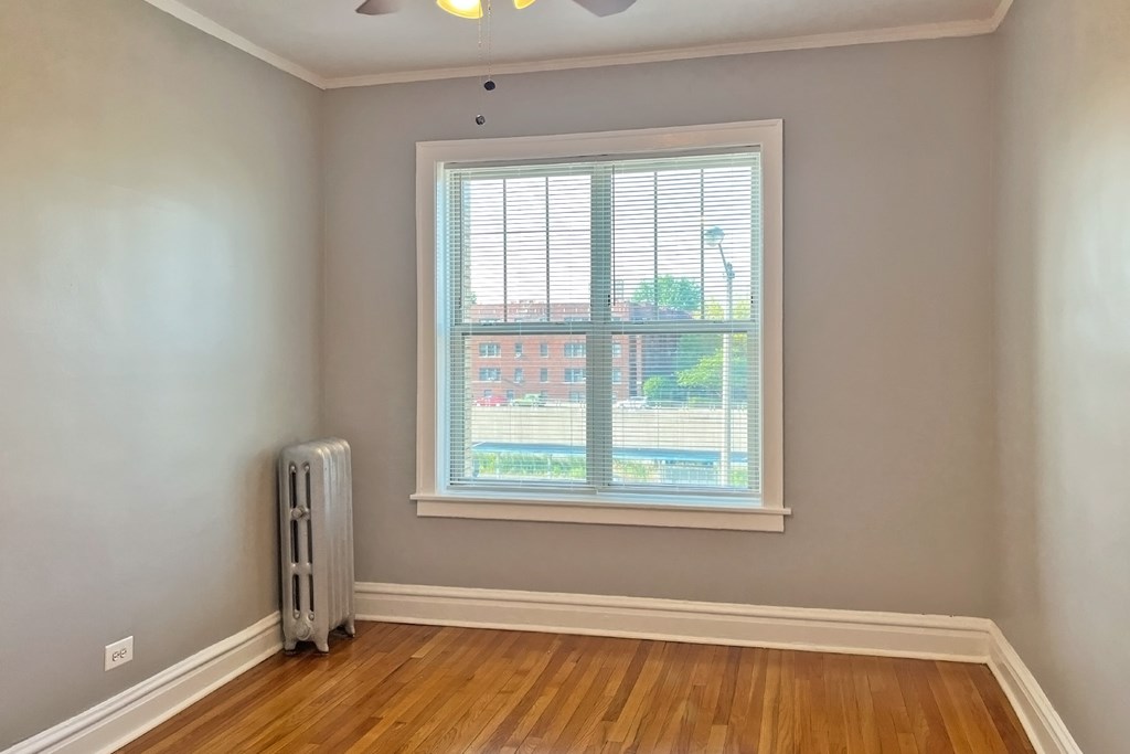 A room with a window and a radiator on the floor.