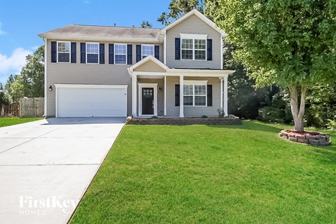 a suburban house with a lawn and a white driveway