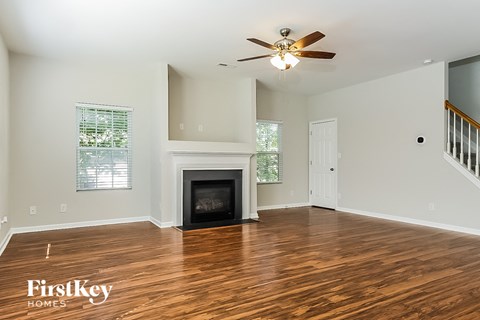a living room with a fireplace and a ceiling fan