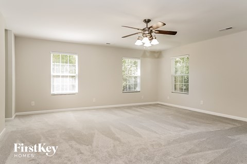 the master bedroom is spacious and clean with a ceiling fan