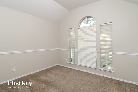the second bedroom has a large window and carpeted flooring