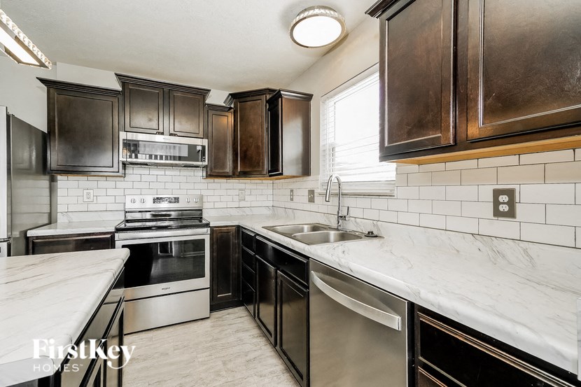 A kitchen with a stainless steel dishwasher and oven.