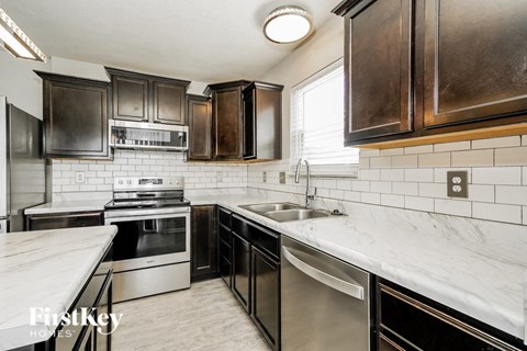 A kitchen with a stainless steel dishwasher and oven.