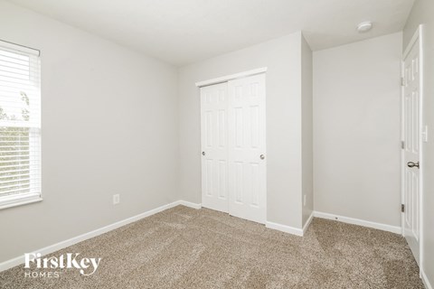 A room with a carpeted floor and a white door.