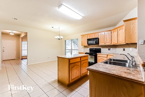 A kitchen with wooden cabinets and a granite countertop.