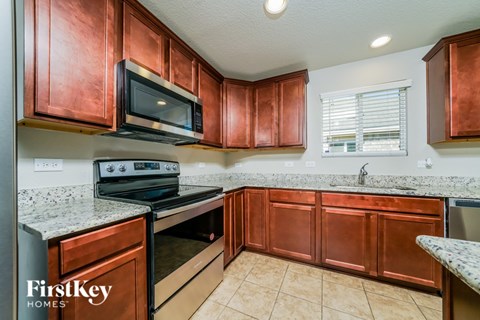 A kitchen with copper cabinets and a stove top oven.