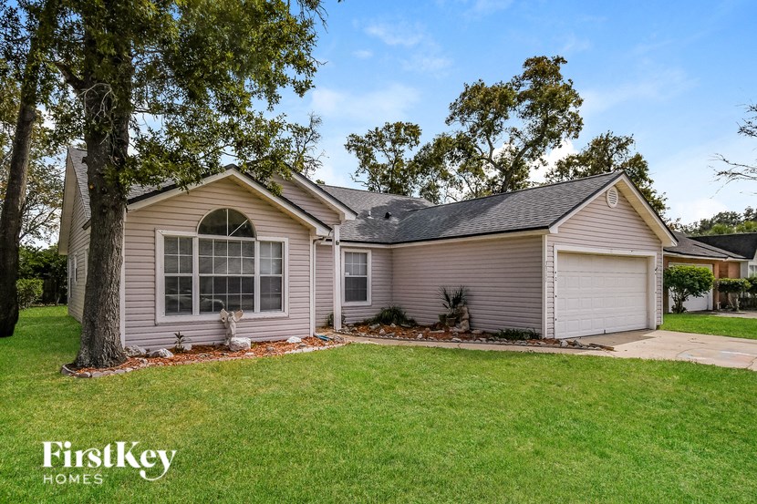 a home with a lawn and a tree in front of it