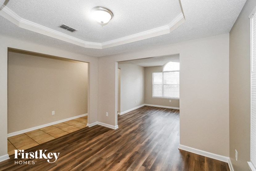 the living room and dining room with hardwood flooring and a window