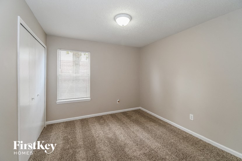 an empty room with carpet and a window