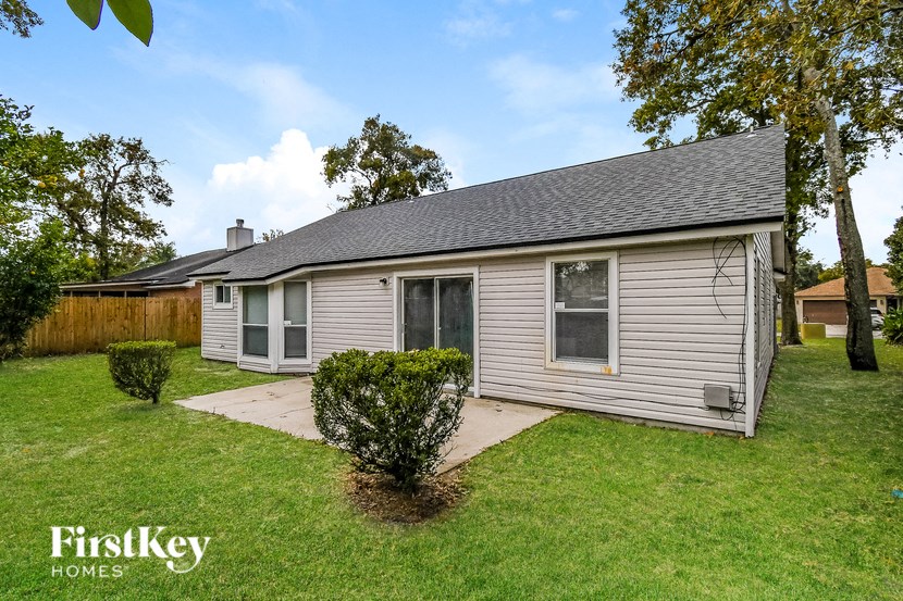 a small white house with a yard and a backyard