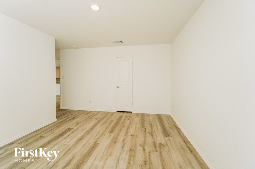 a room with white walls and wooden floors and a white door