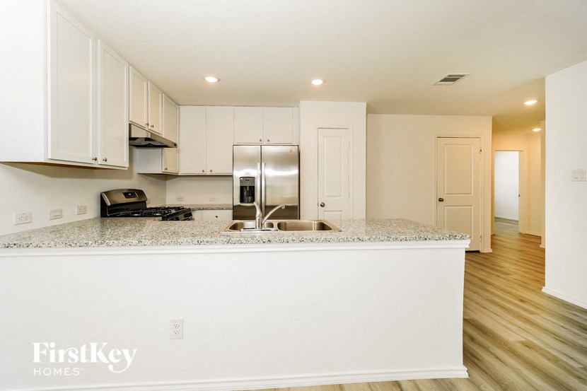 a kitchen with white cabinets and a granite counter top