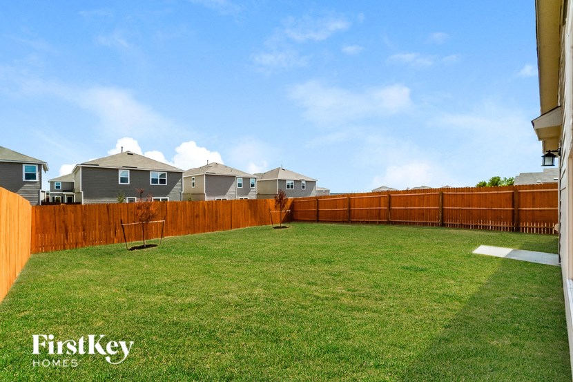 a backyard with a wooden fence and a lawn