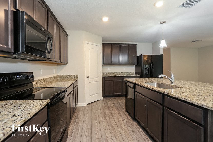 a kitchen with granite counter tops and dark wood cabinets