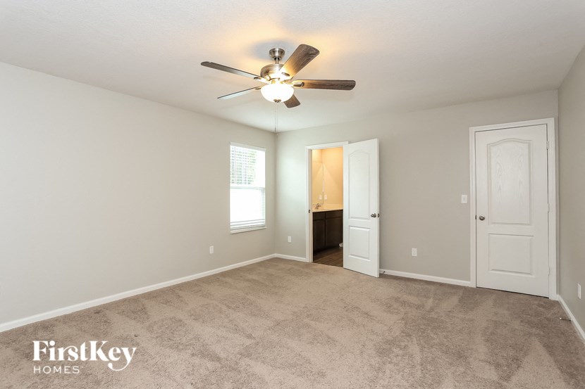 a living room with carpet and a ceiling fan