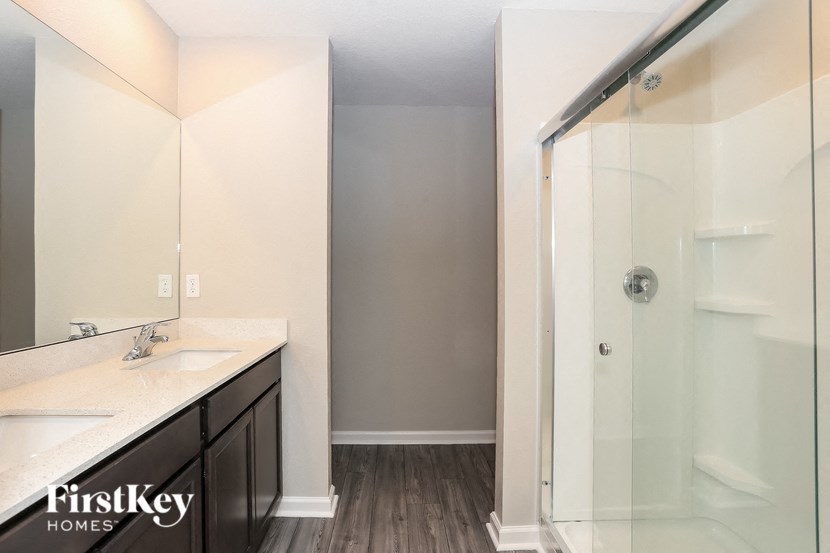 a bathroom with a shower and a sink and a mirror