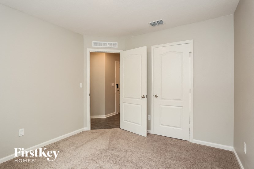 a bedroom with two closets and a door to a hallway
