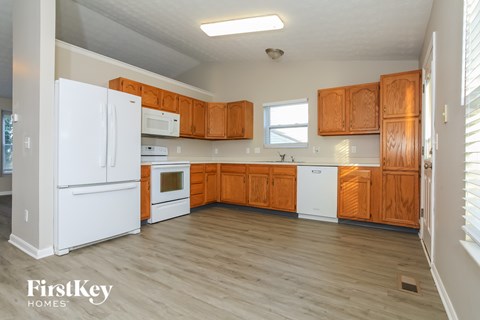 A kitchen with wooden cabinets and white appliances.