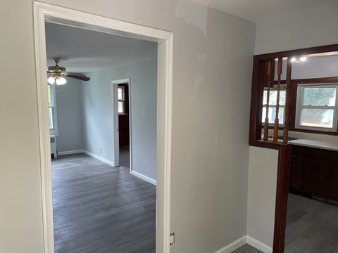 A room with a ceiling fan and wooden flooring.