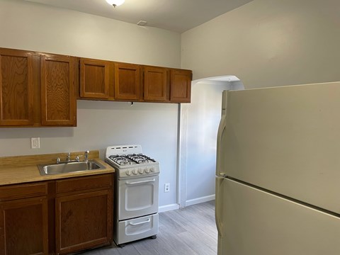 A kitchen with a white stove and wooden cabinets.