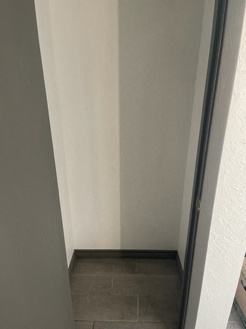 an empty hallway with a door open to a room