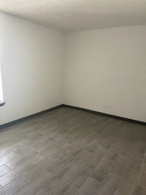 an empty room with wood flooring and white walls